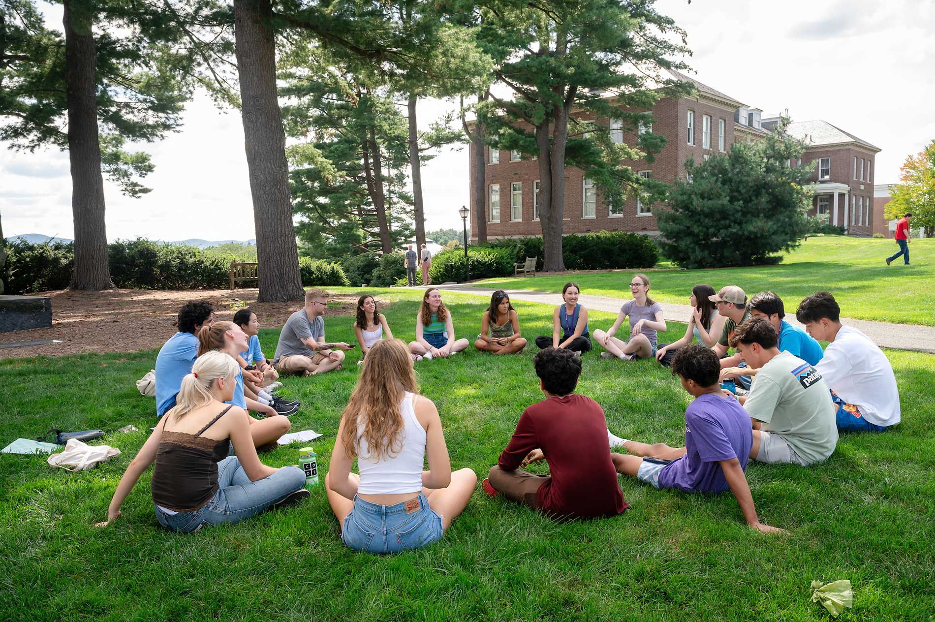 New students sit in a circle on the academic quad.