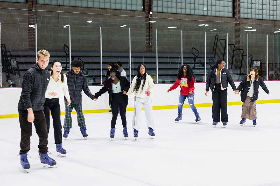 A large group of students ice skating in Orr Rink.