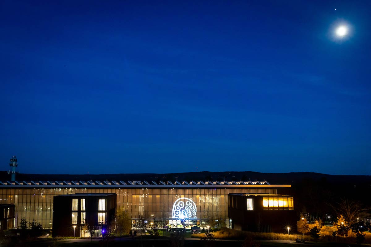 The exterior of the Science Center at night under a full moon.