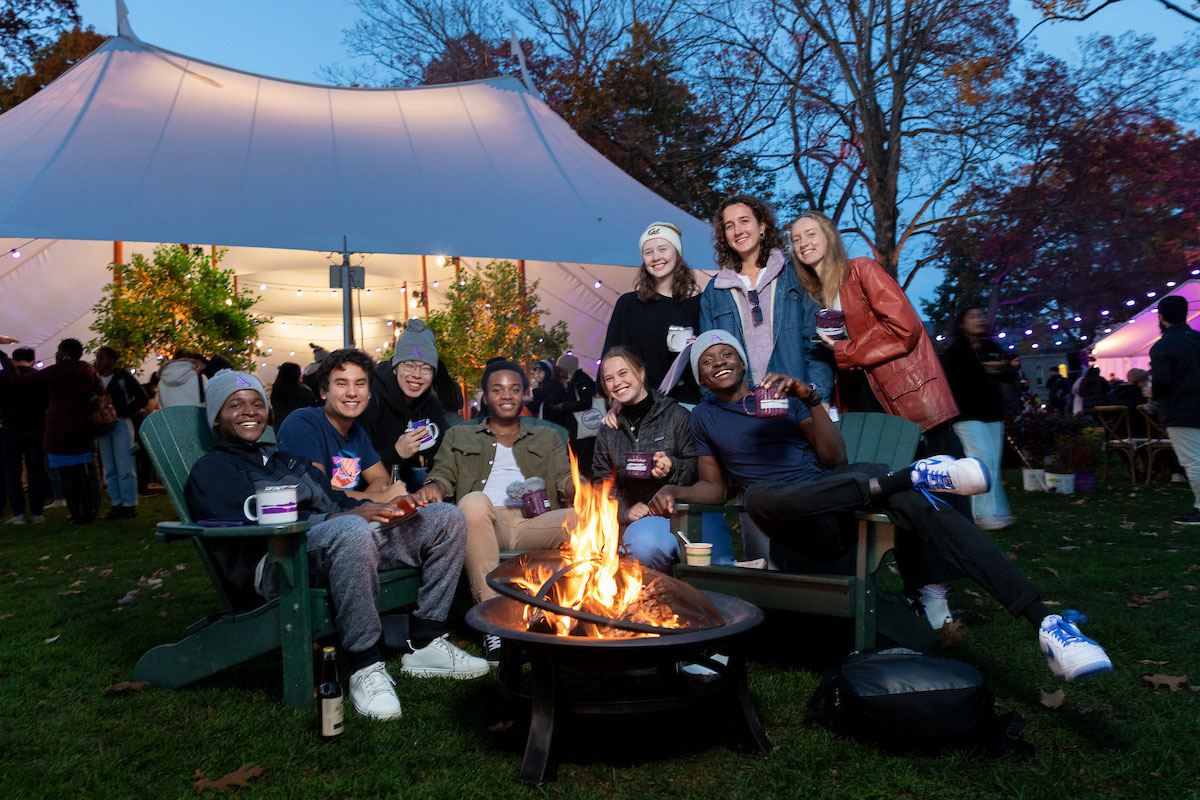 Students gather around a firepit.