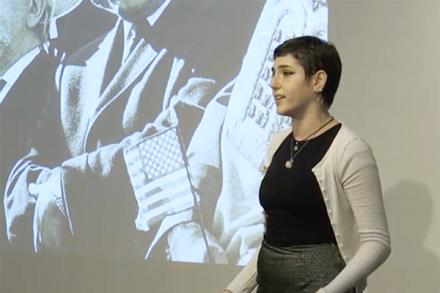 A young woman speaking in front of a projected image